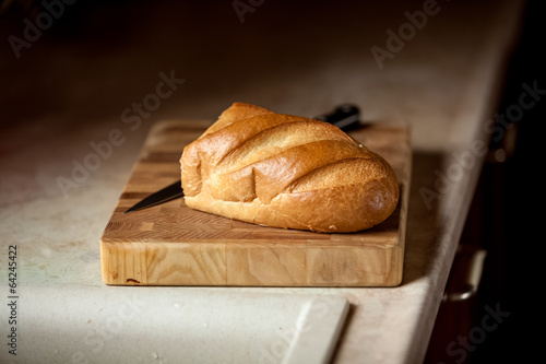 Photo: photo of bread and knife on wooden desk photo of bread and knife on wooden desk