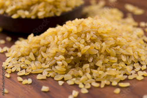 Photo: bulgur wheat in wooden spoon bulgur wheat in wooden spoon