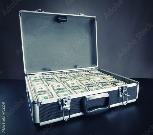 Photo: Case full of money on gray background Case full of money on gray background
