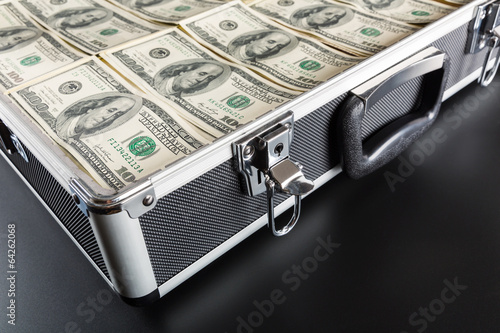 Photo: Case full of money on gray background Case full of money on gray background