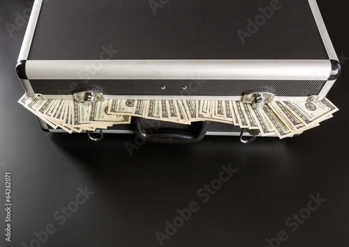 Photo: Case full of money on gray background Case full of money on gray background