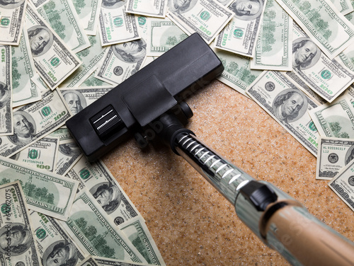 Photo: Money on the floor vacuuming with vacuum cleaner Money on the floor vacuuming with vacuum cleaner