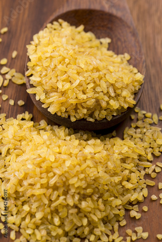 Photo: bulgur wheat in wooden spoon bulgur wheat in wooden spoon