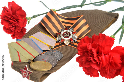 Photo: Soviet military cap, red flowers, Saint George ribbon, medals of Soviet military cap, red flowers, Saint George ribbon, medals of