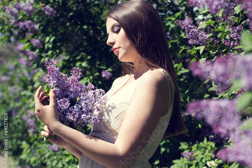 Photo: Beautiful girl with a lilac flowers Beautiful girl with a lilac flowers