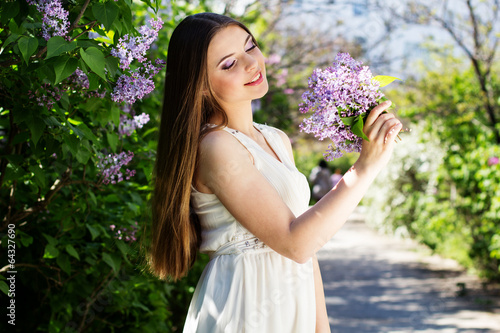 Photo: Beautiful girl with a lilac flowers Beautiful girl with a lilac flowers