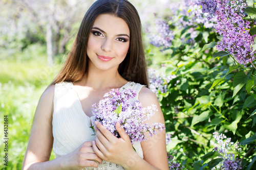 Photo: Beautiful girl with a lilac flowers Beautiful girl with a lilac flowers