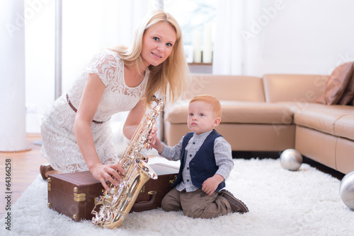 Photo: Mama zeigt Junge wie man Saxophone spielt Mama zeigt Junge wie man Saxophone spielt