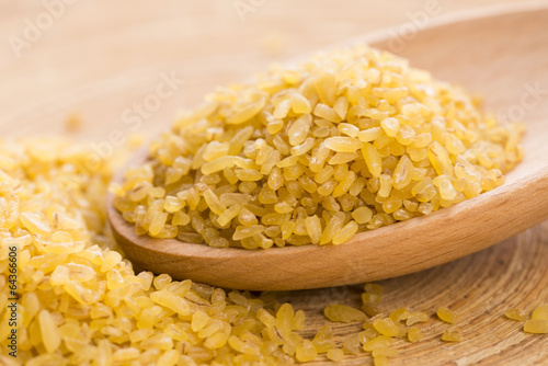 Photo: bulgur wheat in wooden spoon bulgur wheat in wooden spoon