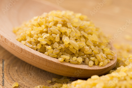 Photo: bulgur wheat in wooden spoon bulgur wheat in wooden spoon