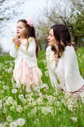 Photo: Mother and daughter in field with dandelions Mother and daughter in field with dandelions