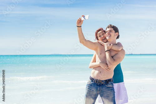 Photo: Young Couple Taking Selfie at Beach Young Couple Taking Selfie at Beach