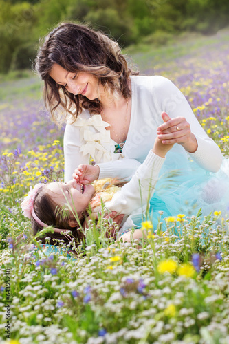Photo: Mother and daughter in field with colorful flowers Mother and daughter in field with colorful flowers