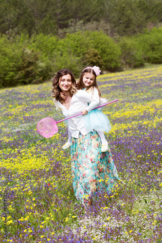 Photo: Mother and daughter in field with colorful flowers Mother and daughter in field with colorful flowers