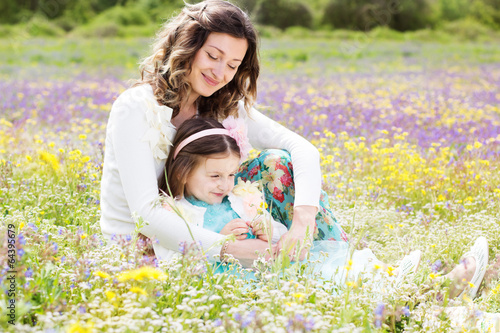 Photo: Mother and daughter in field with colorful flowers Mother and daughter in field with colorful flowers
