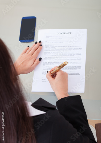 Photo: Businesswoman Signing Contract Papers Businesswoman Signing Contract Papers
