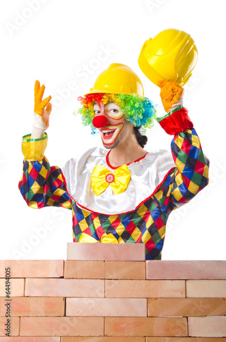 Photo: Bad construction concept with clown laying bricks Bad construction concept with clown laying bricks