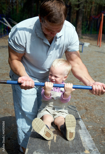 Photo: Dad and his little son do exercises Dad and his little son do exercises