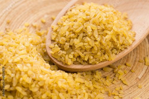 Photo: bulgur wheat in wooden spoon bulgur wheat in wooden spoon