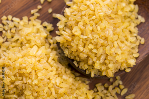 Photo: bulgur wheat in wooden spoon bulgur wheat in wooden spoon