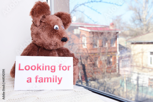 Photo: Toy-bear looking out window close-up Toy-bear looking out window close-up