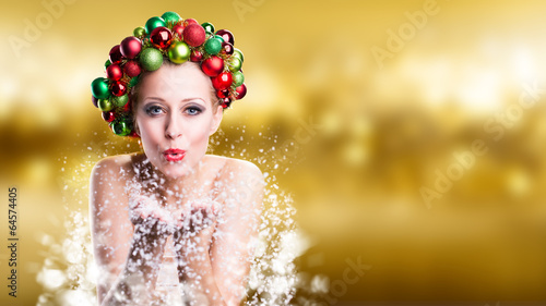 Photo: Weihnachtlich geschmückte Frau pustet Schnee Weihnachtlich geschmückte Frau pustet Schnee