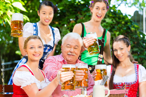 Photo: Im Biergarten - Freunde trinken Bier in Bayern Im Biergarten - Freunde trinken Bier in Bayern