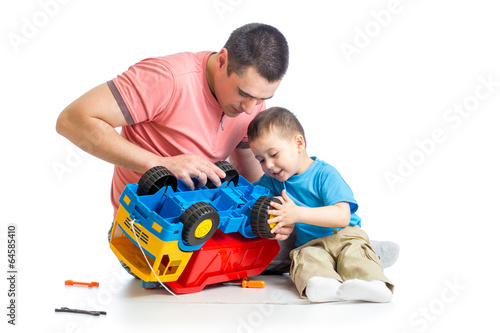 Photo: kid boy and his dad repair toy trunk kid boy and his dad repair toy trunk