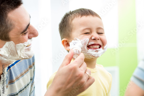 Photo: playful kid and father shaving together at home bathroom playful kid and father shaving together at home bathroom