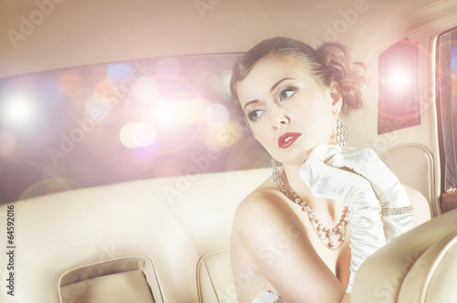 Photo: Beautiful and rich superstar girl sitting in a retro car Beautiful and rich superstar girl sitting in a retro car