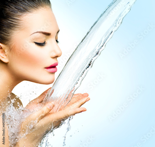 Photo: Beautiful model woman with splashes of water in her hands Beautiful model woman with splashes of water in her hands
