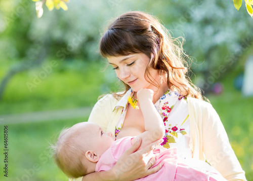 Photo: young mother breast feeding her baby girl outdoors young mother breast feeding her baby girl outdoors