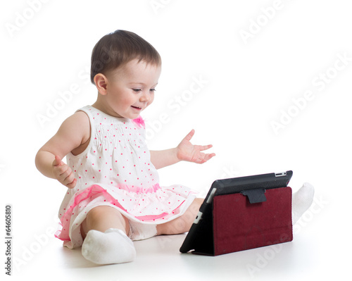 Photo: kid girl playing with a digital tablet kid girl playing with a digital tablet