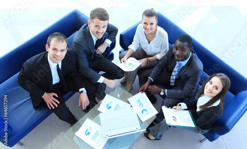 Photo: Top view of working business group sitting at table Top view of working business group sitting at table