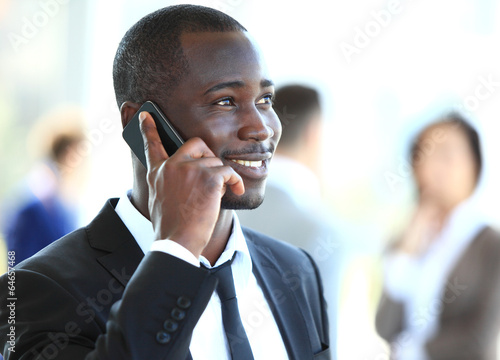 Photo: handsome african american businessman talking on mobile phone handsome african american businessman talking on mobile phone