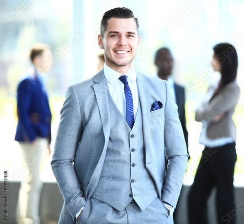Photo: Happy smart business man with team mates discussing Happy smart business man with team mates discussing