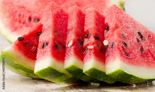 Photo: slices of watermelon on wooden table slices of watermelon on wooden table