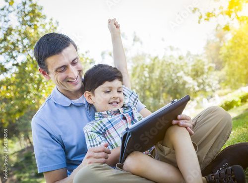 Photo: Handsome Mixed Race Father and Son Playing on Computer Tablet Handsome Mixed Race Father and Son Playing on Computer Tablet
