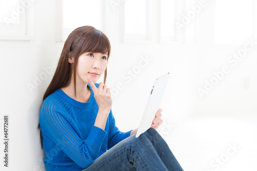 Photo: 部屋でタブレットを見る女性 部屋でタブレットを見る女性