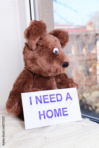 Photo: Toy-bear looking out window close-up Toy-bear looking out window close-up