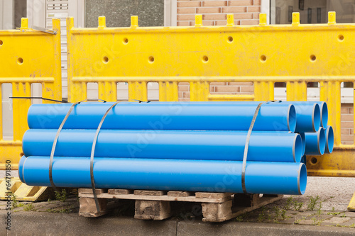 Photo: Blaue Rohre aus Kunststoff vor gelben Absperrbaken Blaue Rohre aus Kunststoff vor gelben Absperrbaken