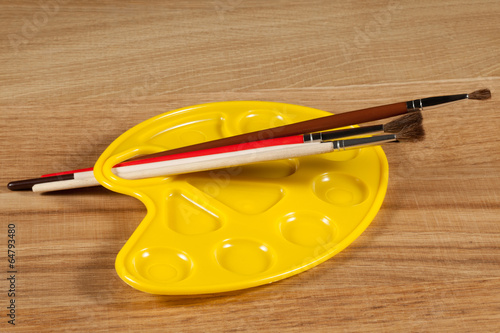 Photo: empty palette with paintbrush for watercolors on a wooden backgr empty palette with paintbrush for watercolors on a wooden backgr