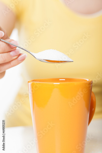 Photo: Woman sweetening drink Woman sweetening drink