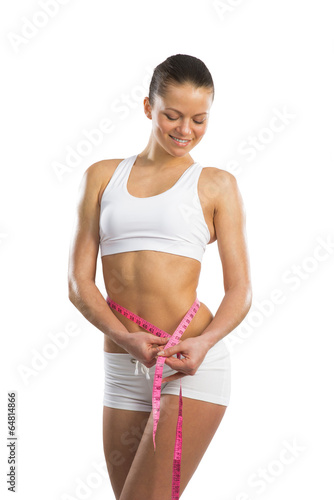 Photo: young athletic woman measuring waist young athletic woman measuring waist