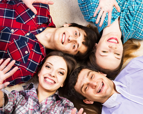 Photo: four young men lie together four young men lie together