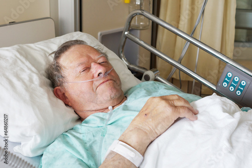 Man in hospital bed - 64860217