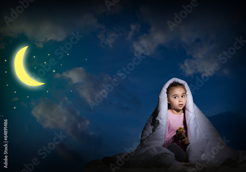 Photo: girl under the covers with a flashlight girl under the covers with a flashlight