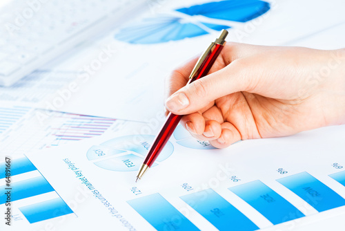 Photo: female hand pointing to the financial growth chart female hand pointing to the financial growth chart
