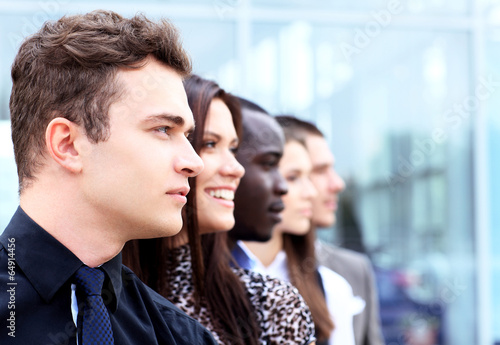 Photo: business team standing in a row at office and looking upwards business team standing in a row at office and looking upwards