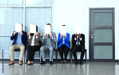 Photo: Young businessman waiting for job interview and holding signboar Young businessman waiting for job interview and holding signboar